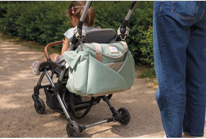 Béaba Sydney II changing bag in leaf green with tan handles on pram