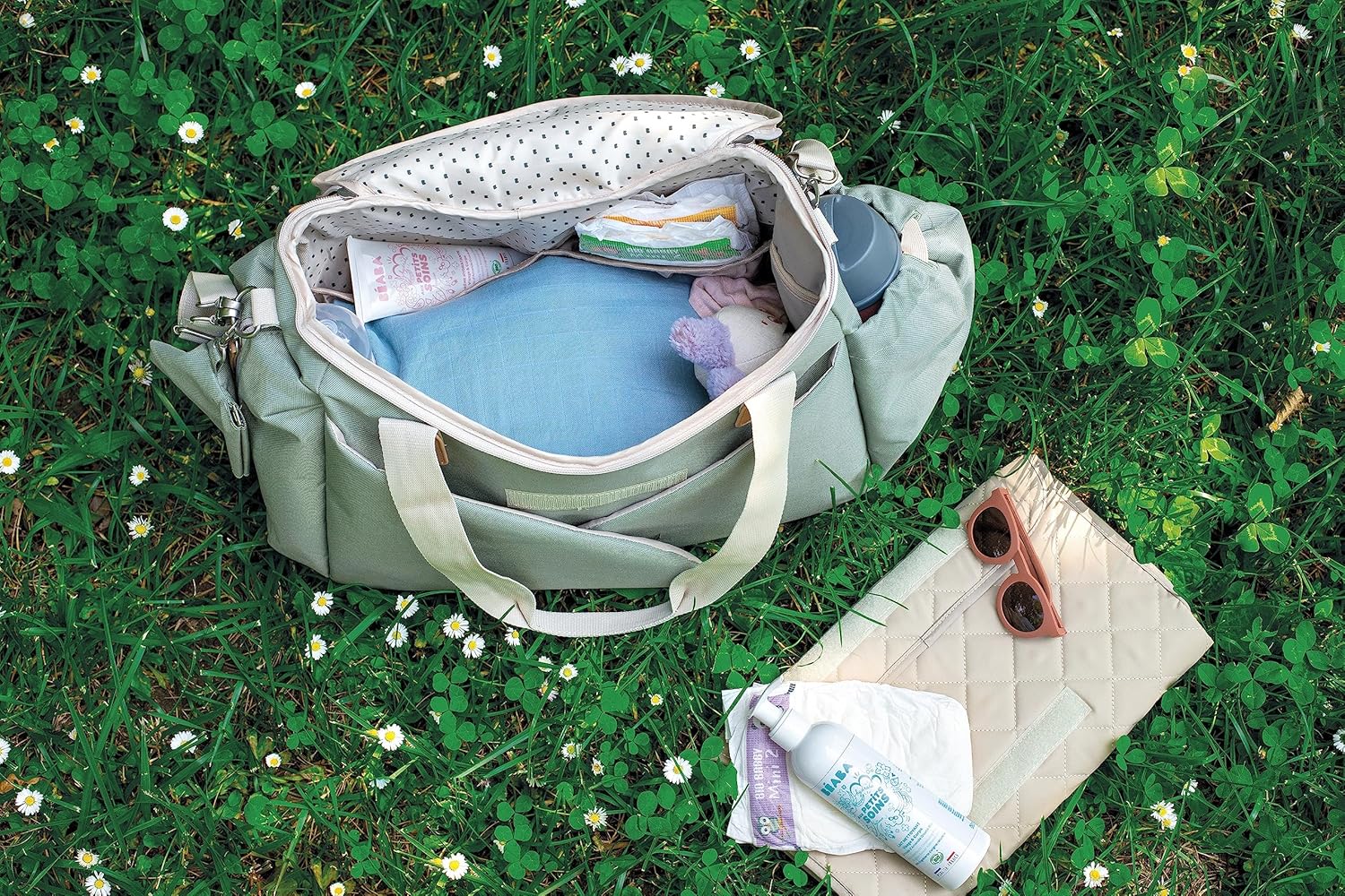 Béaba Sydney II changing bag in leaf green with cream handles, open to show interior storage compartments