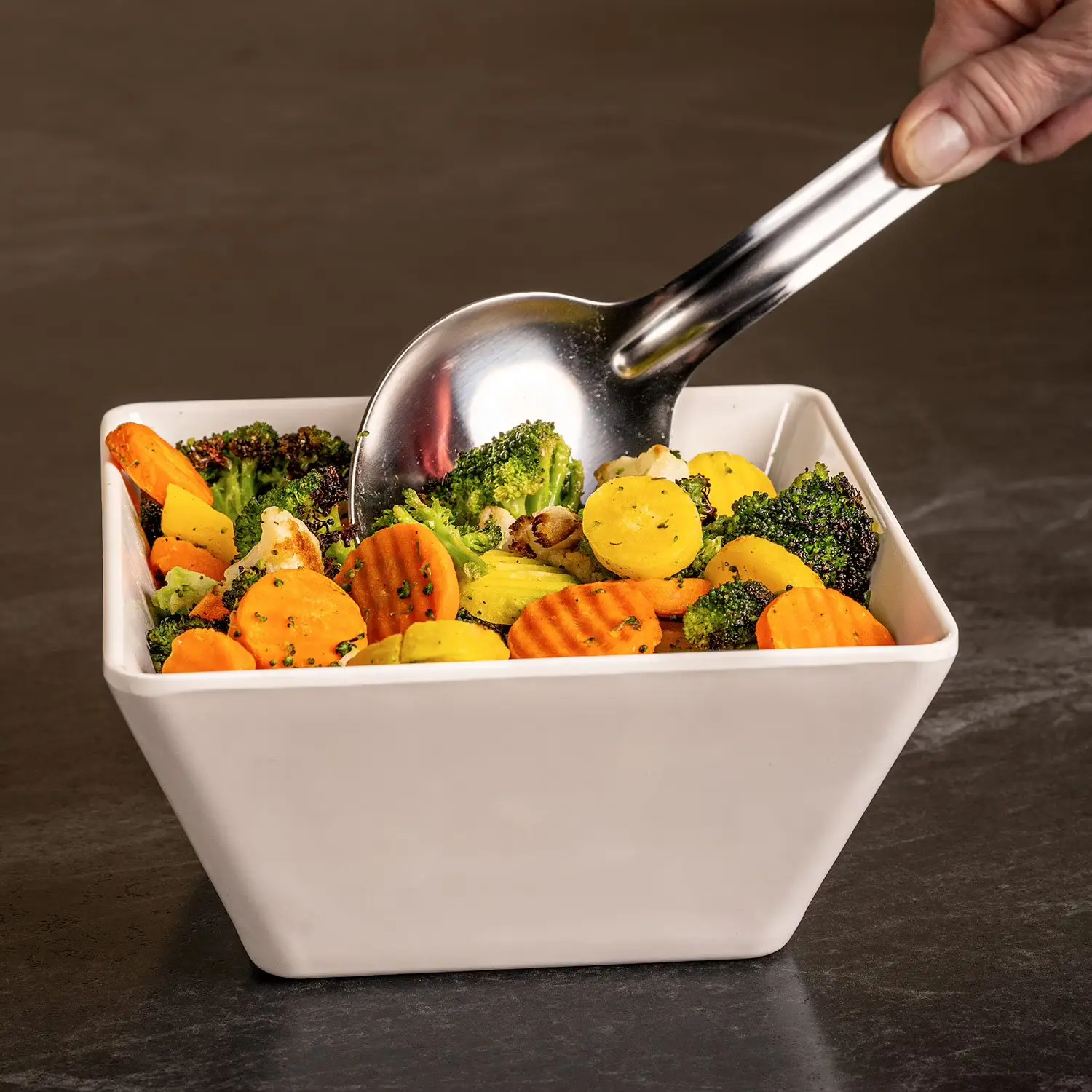 Member's Mark stainless steel kitchen spoon with wooden handle in use
