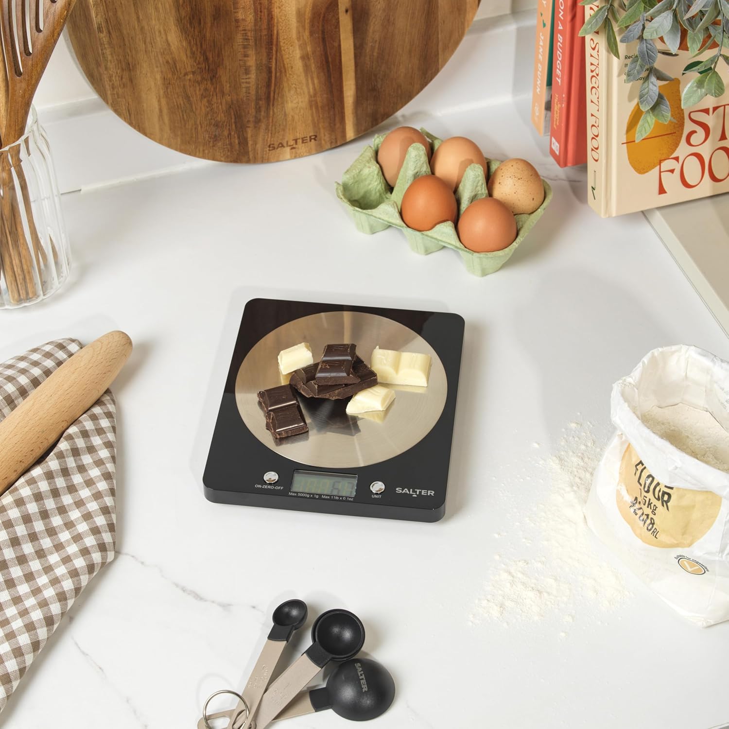 Salter black electronic kitchen scale with stainless steel platform displaying food items
