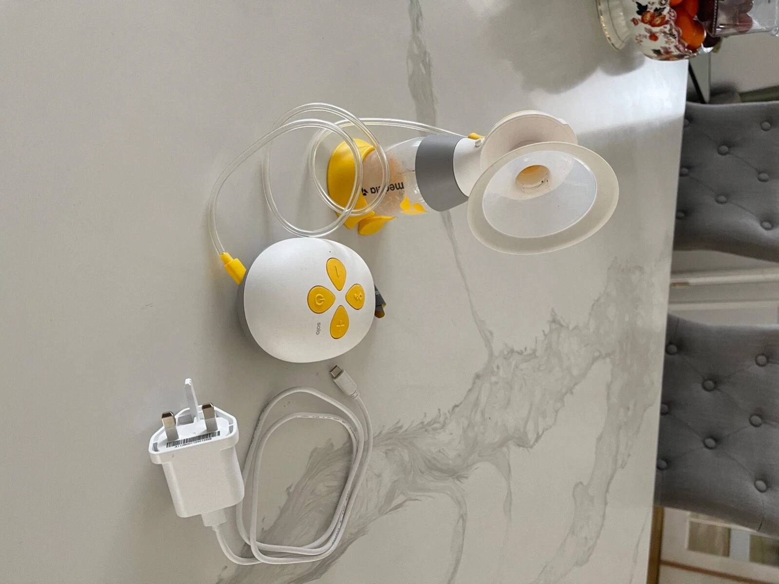Medela Swing Flex single electric breast pump with yellow accents and tubing displayed with accessories