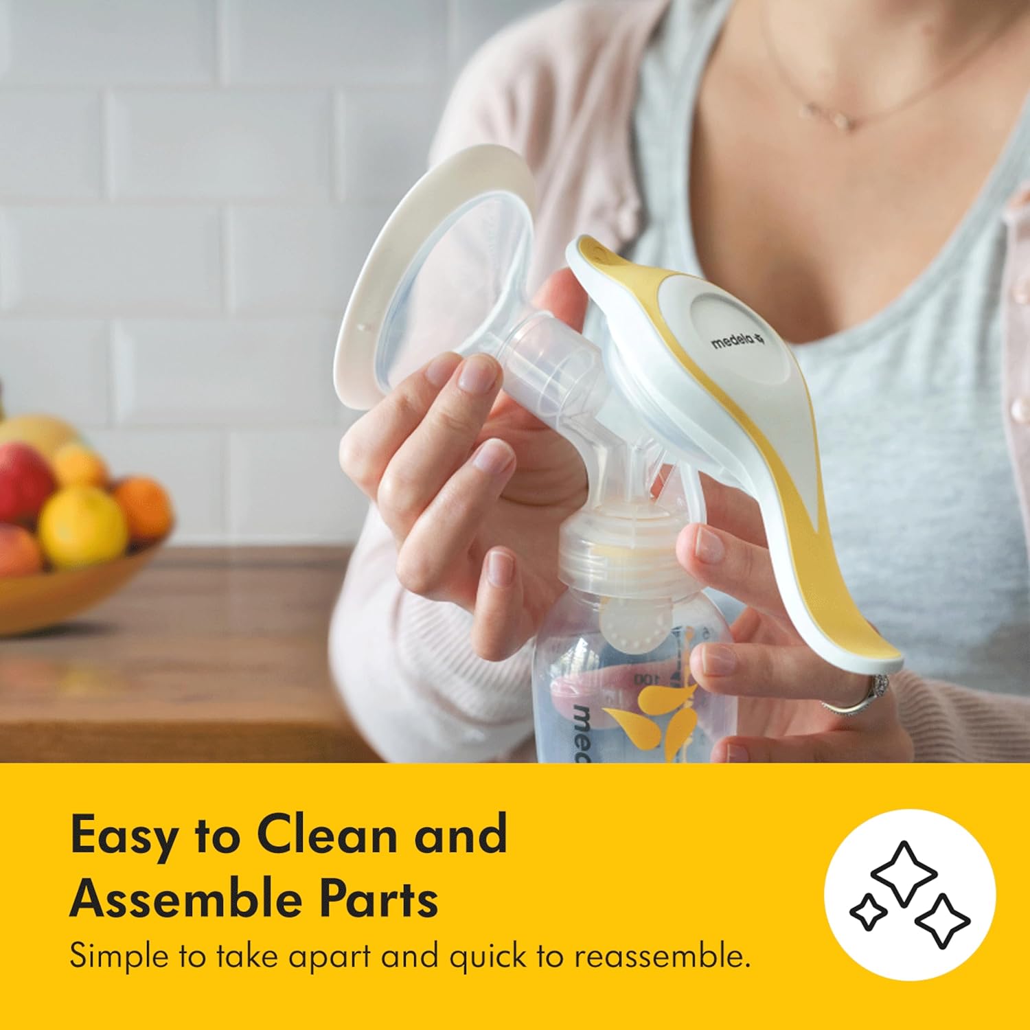 Medela Harmony Flex manual breast pump with white and gold components and collection bottle