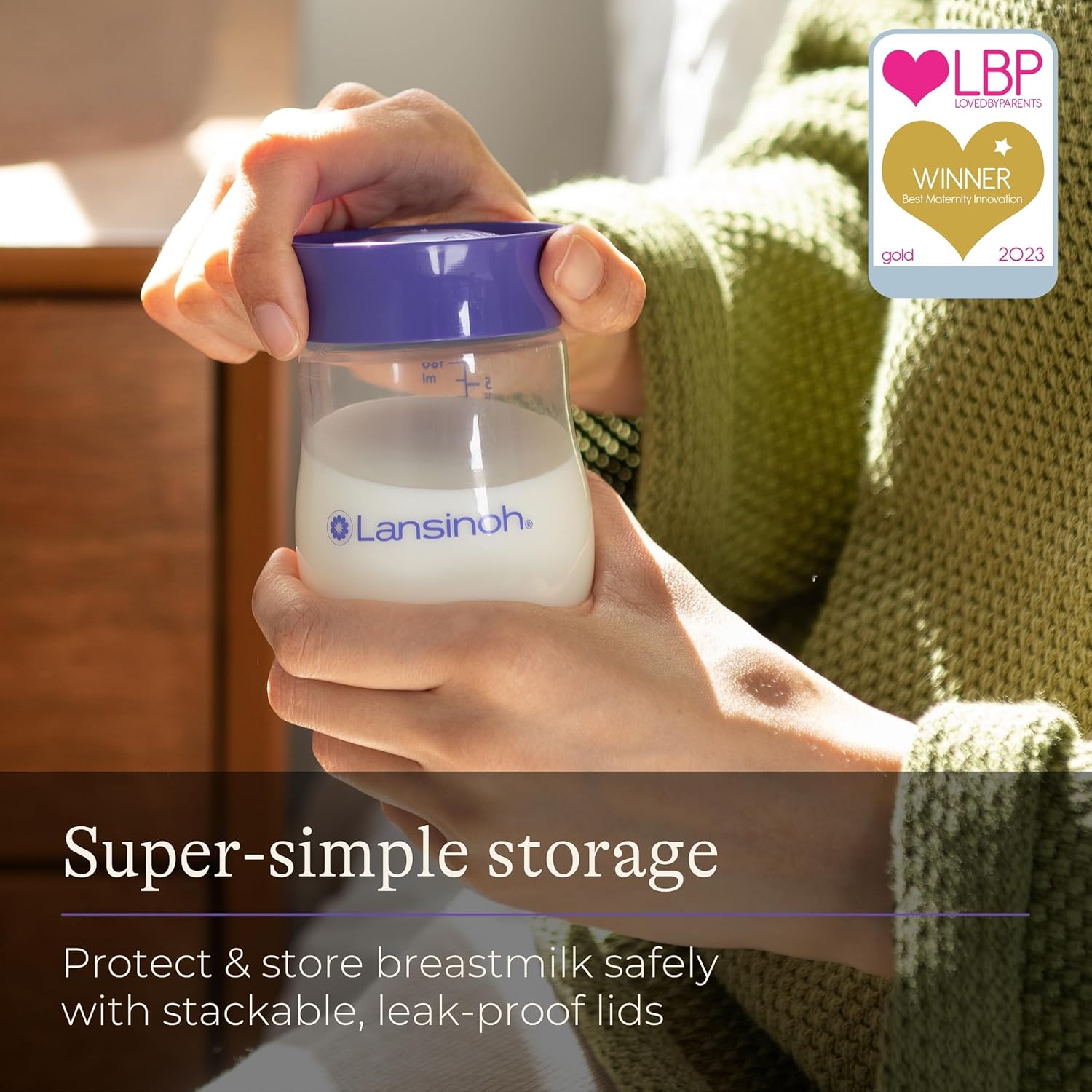 Lansinoh breastmilk storage bottle 160ml with purple lid held in hand