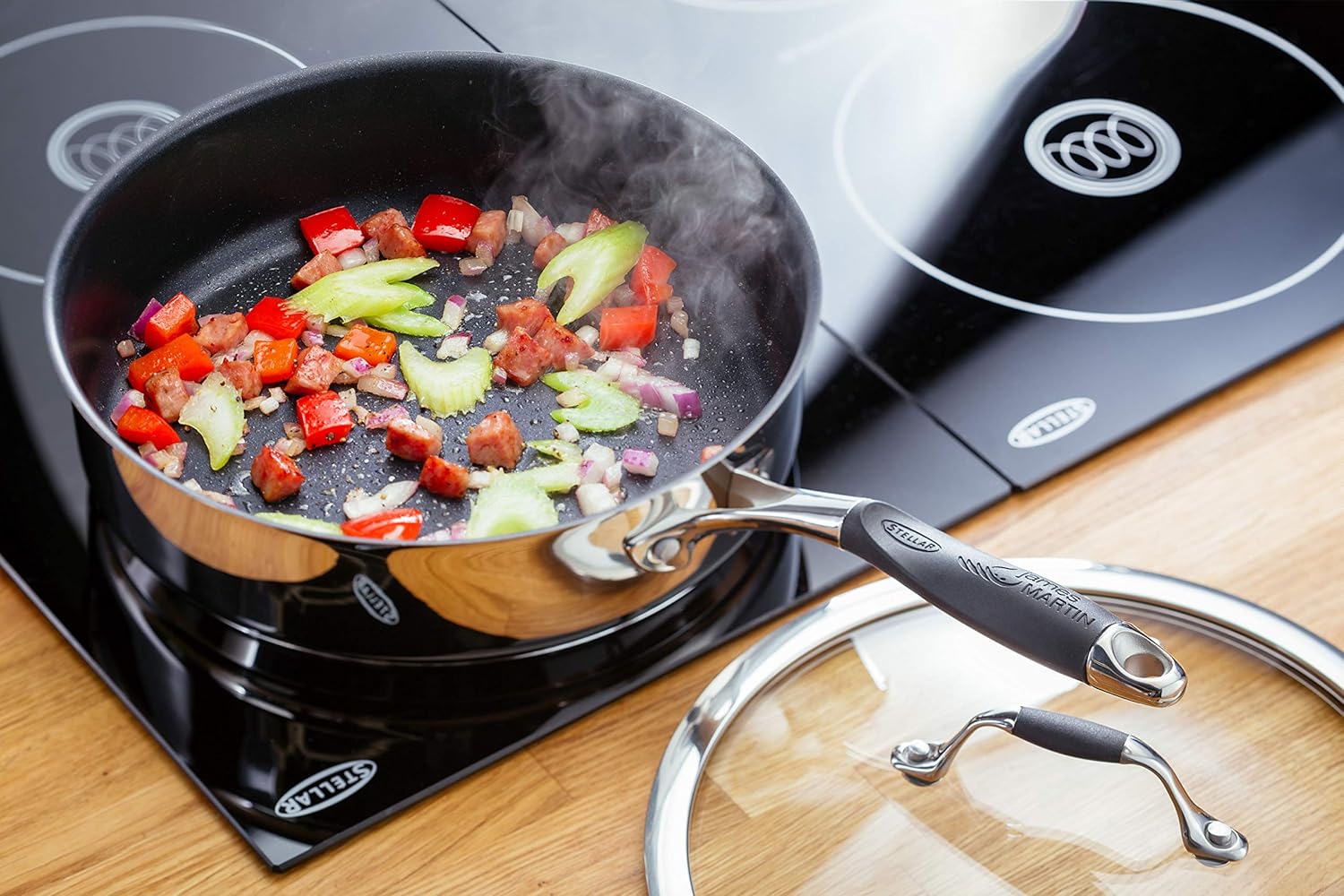 Stellar James Martin 24cm black non-stick saute pan with vegetables cooking inside