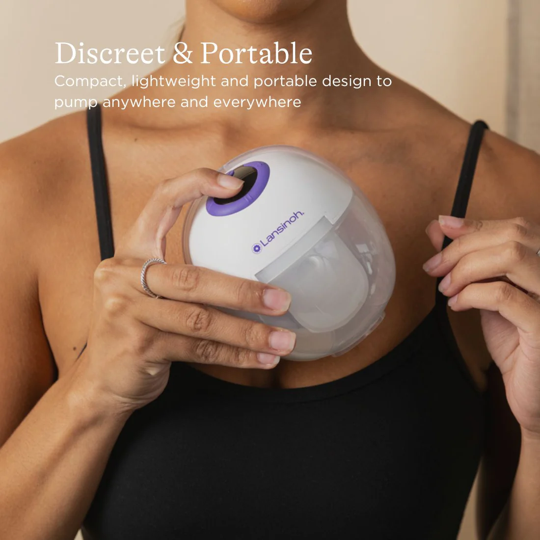Lansinoh Wearable Double Pump Single white and purple breast pump held in hands